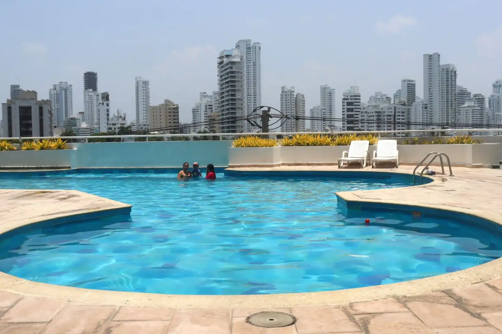 Pareja disfrutando de la Vista de la Piscina Panorámica del Edificio Torres del Lago, barrio El Laguito