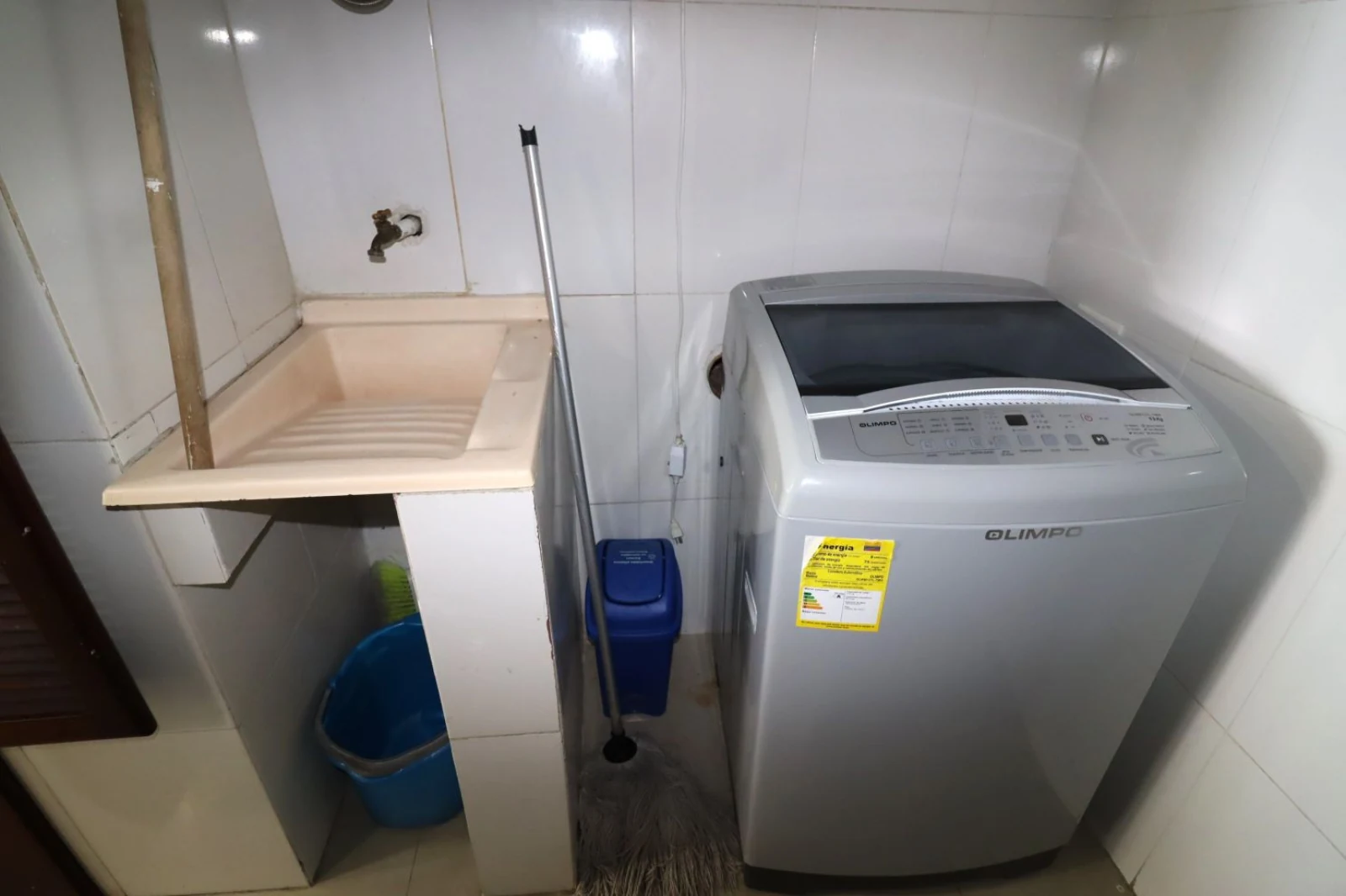 Área de lavado con lavadora y mesón de lavado en el Apartamento Alojamiento Familiar en Torres del Lago 1502B