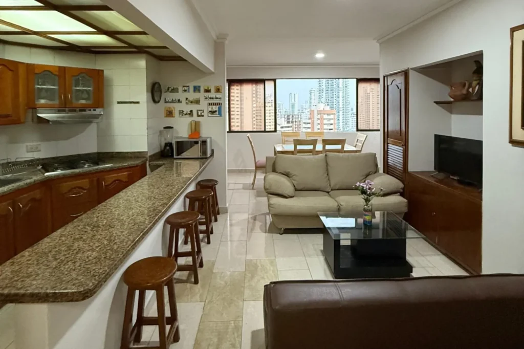 Vista de la Cocina amplia con mesón americano y salida a la sala y comedor del apartamento 1702AT del alojamiento dos alcobas Cartagena Escape Plaza