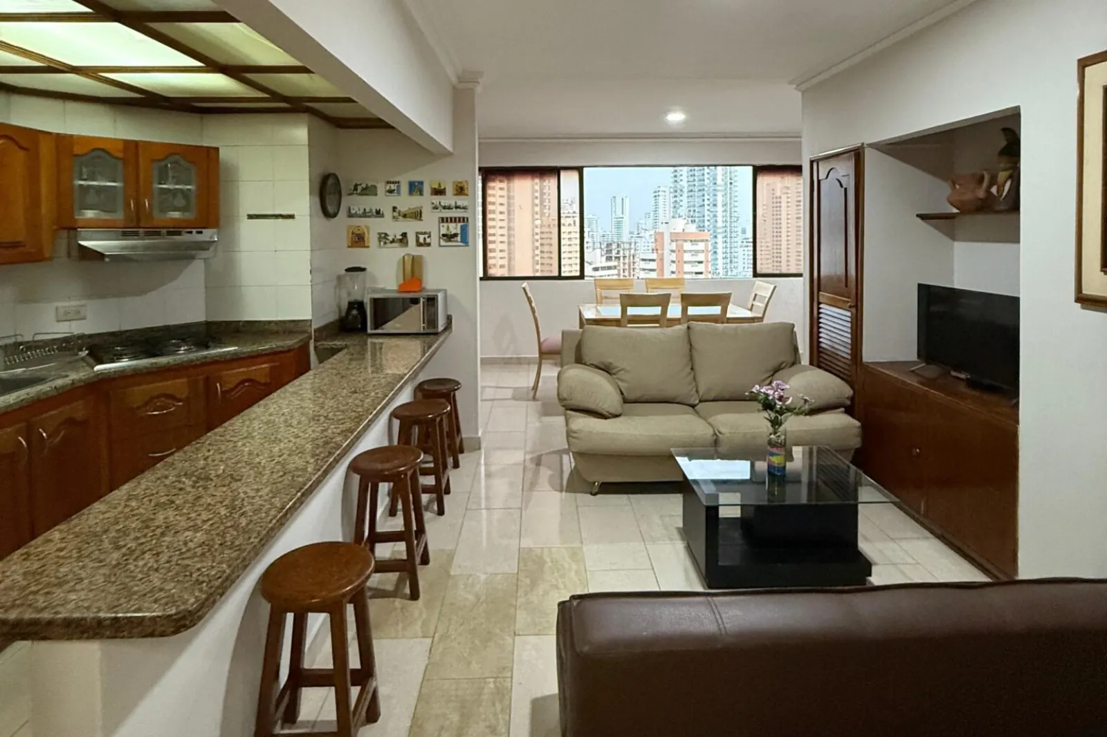 Vista de la Cocina amplia con mesón americano y salida a la sala y comedor del apartamento 1702AT del alojamiento dos alcobas Cartagena Escape Plaza