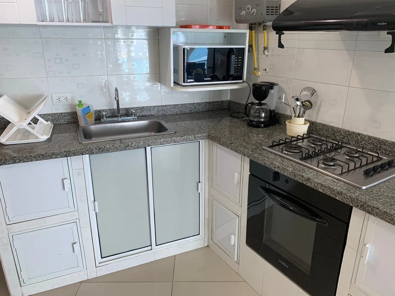 Cocina impecable equipada con electrodomésticos y vajillas del apartamento 1607 edificio Poseidón del Caribe con jacuzzi